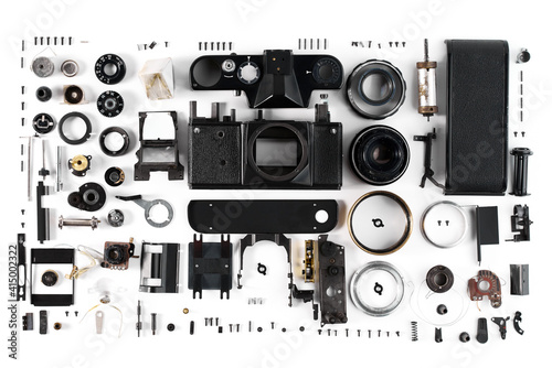 top view of a disassembled film camera, the details of which are meticulously laid out on a white surface photo
