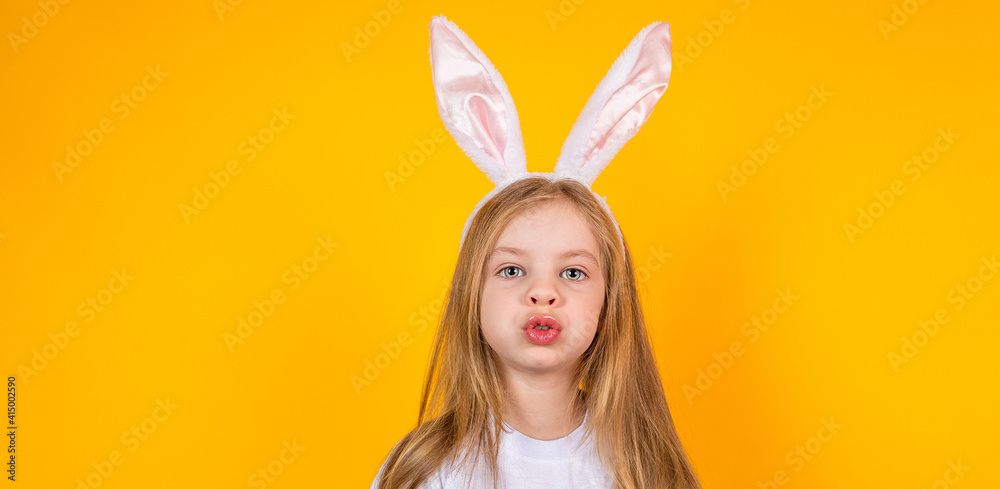 Portrait of an Easter girl with bunny ears on a yellow background