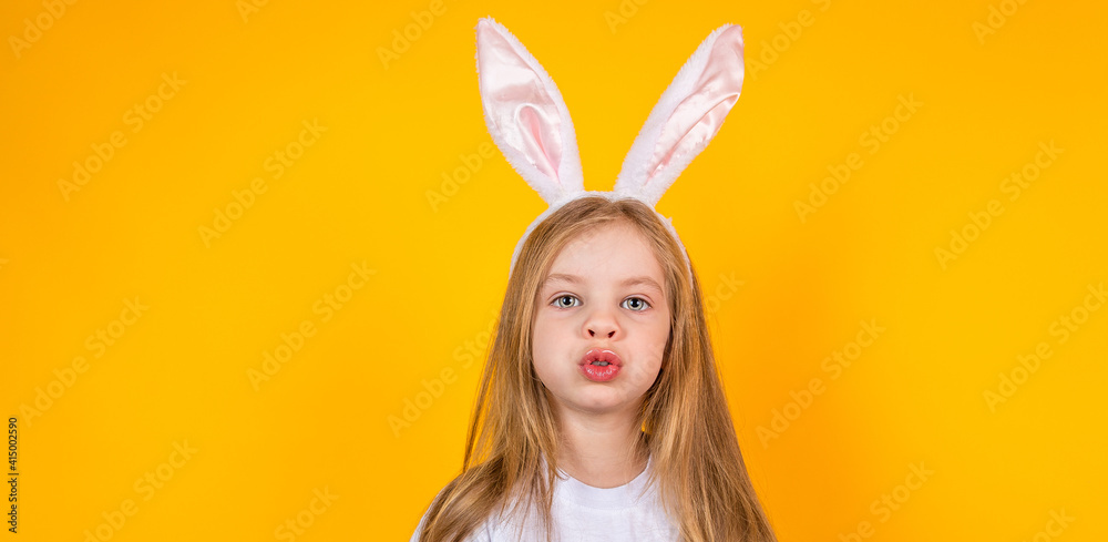 Portrait of an Easter girl with bunny ears on a yellow background Portrait of an Easter girl with bunny ears on a yellow background
