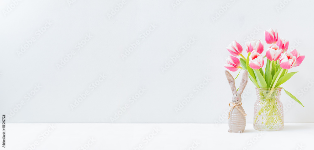 Fototapeta premium Home interior with easter decor. Pink tulips in a vase on a light background