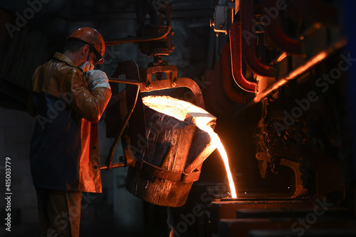 Tableau sur toile A steelmaker pours pig iron from a blast furnace, sparks and splashes of hot metal fly
