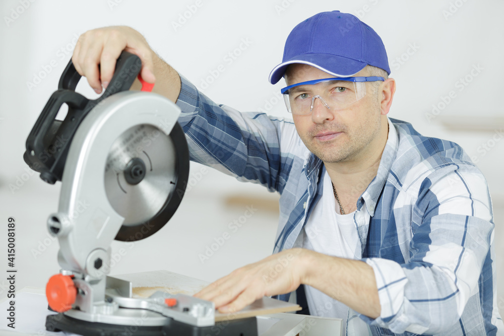carpenters cutting wooden plank with a circular saw carpenters cutting wooden plank with a circular saw