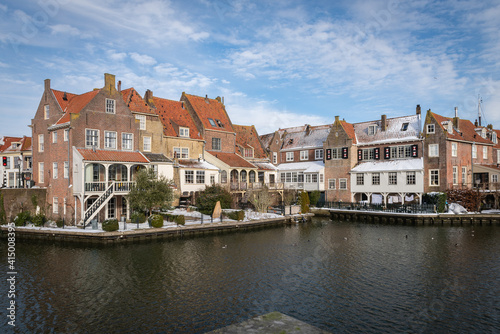 Scenic view of the old Dutch city residential buildings from the other side of the canal in winter
