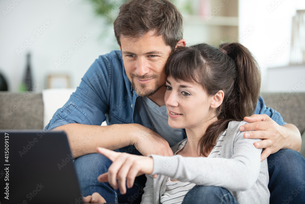 happy couple using a laptop computer happy couple using a laptop computer