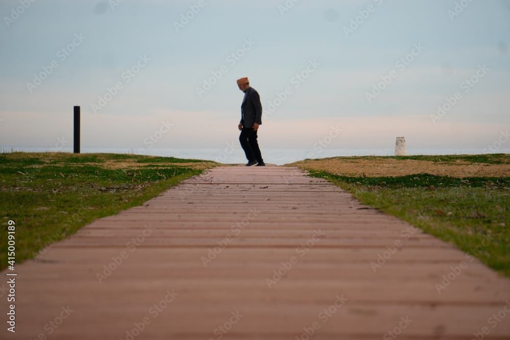 anciano paseado solo en la playa 