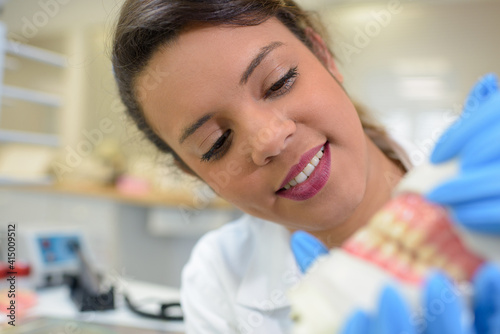 dentist holding a model teeth