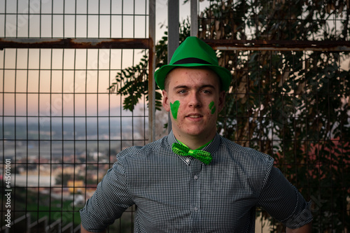 boy wearing a green cap and bow tie at sunset on St. Patrick's Day
