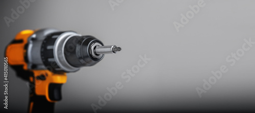 Yellow-black cordless Combi Drill Driver Hammer Drill on gray background.