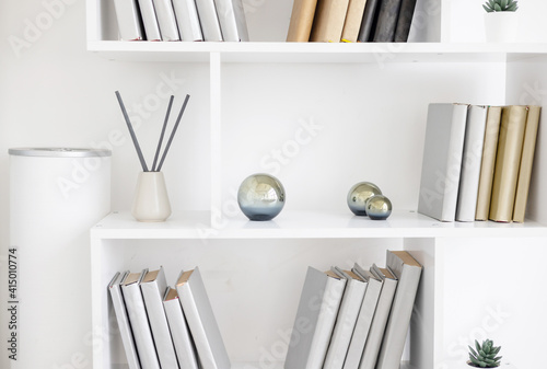 white bookshelves and minimalist design and incense sticks photo