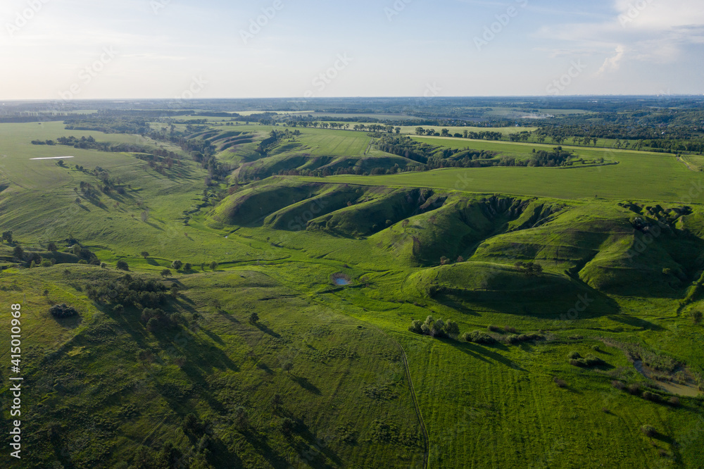 aerial view on the green canyon and fields in summer at sunset