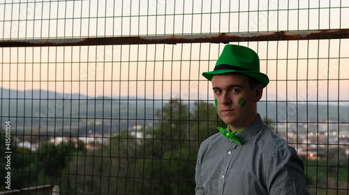 boy wearing a green cap and bow tie at sunset on St. Patrick's Day