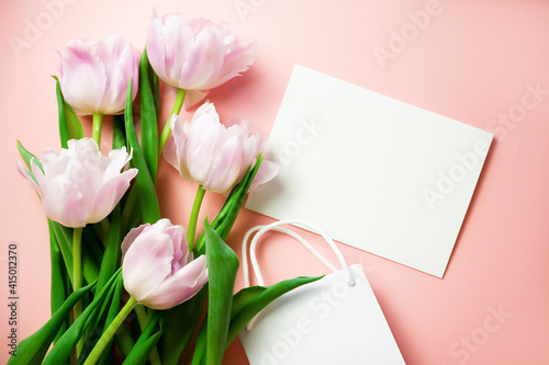 Wallpaper Mural Banner. A bunch of pink tulips on a warm pink background with a card with HAPPY BIRTHDAY text and a gift bag. Flatlay Torontodigital.ca