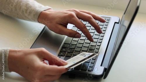 Female hands holding credit card making online payment. Woman consumer paying for purchase in web store using laptop technology. Ecommerce website payments concept.
