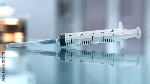Realistic medical disposable syringe with needle on the glass in front of blurred background. 3d illustration photo