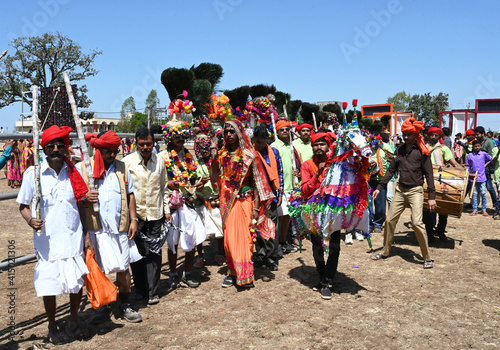 Adivasi tribal men, faces and bodies decorated, wearing ornate headgear, dancing to celebrate Holi festival, Kavant, Gujarat, India photo