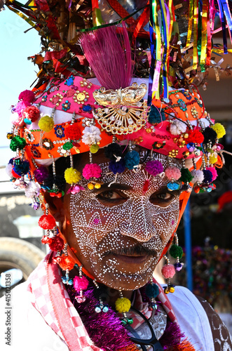 Adivasi tribal man, face decorated and wearing ornate decorated headgear to celebrate Holi festival, Kavant, Gujarat, India photo