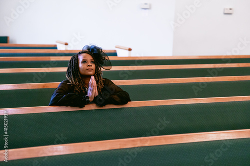 Woman praying to God in Kingdom church home