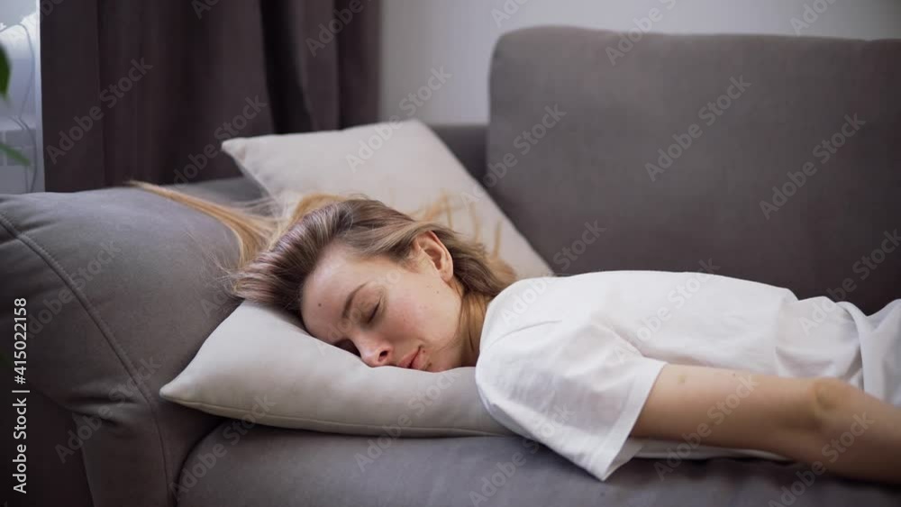 Exhausted or bored young sleepy woman falls down on sofa Exhausted or bored young sleepy woman falls down on sofa
