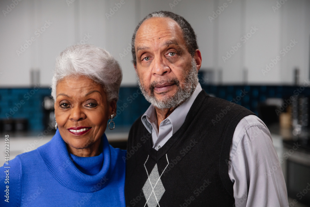 Senior couple at home in kitchen looking at camera, man and woman Senior couple at home in kitchen looking at camera, man and woman