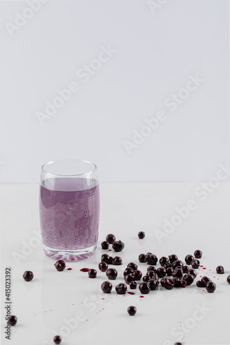 Blackcurrant confiture with a glass of juice on a white background