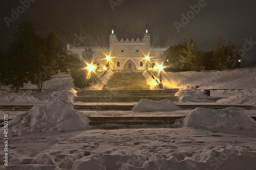 Snow-covered stairs in front of the Lublin Castle illuminated by lanterns photo