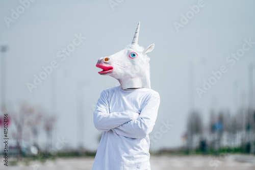 Obraz na plátne Man wearing unicorn mask posing to camera