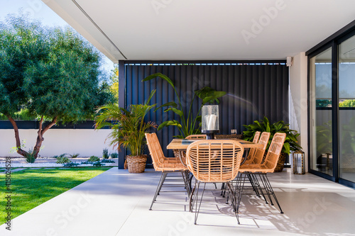 Chairs and table arranged in patio outside house photo