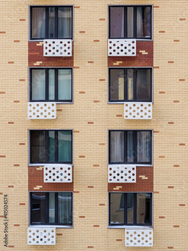 Eight windows with air conditioner's covers on the brick patterned wall