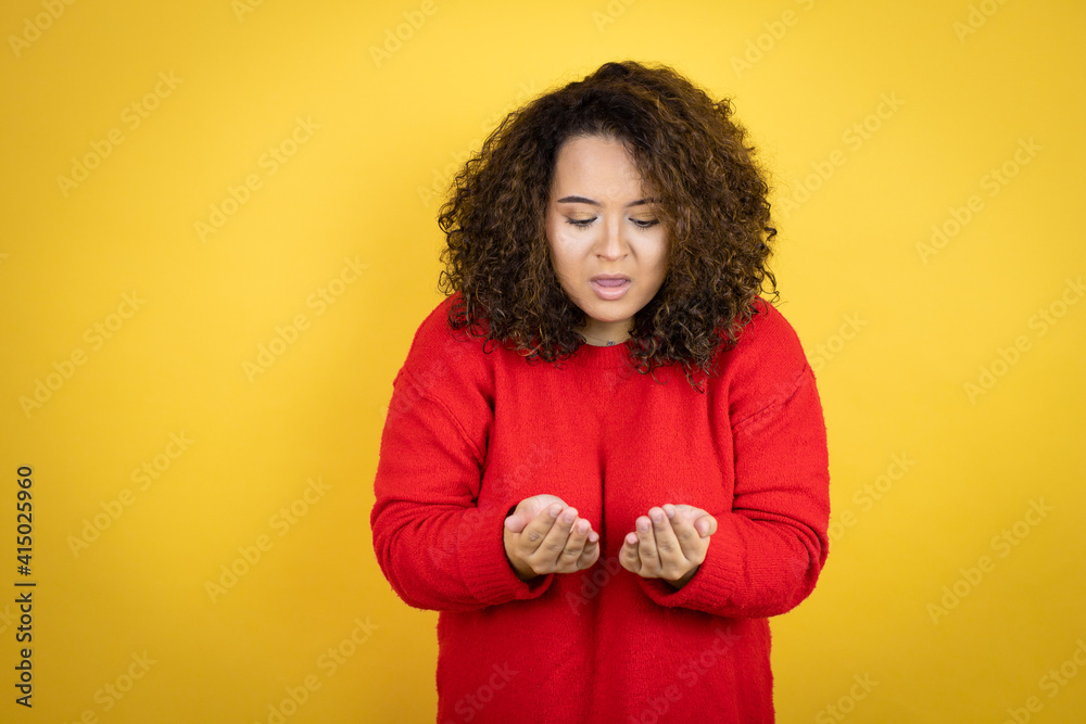 Young african american woman wearing red sweater over yellow background Smiling with hands palms together receiving or giving gesture. Hold and protection Young african american woman wearing red sweater over yellow background Smiling with hands palms together receiving or giving gesture. Hold and protection