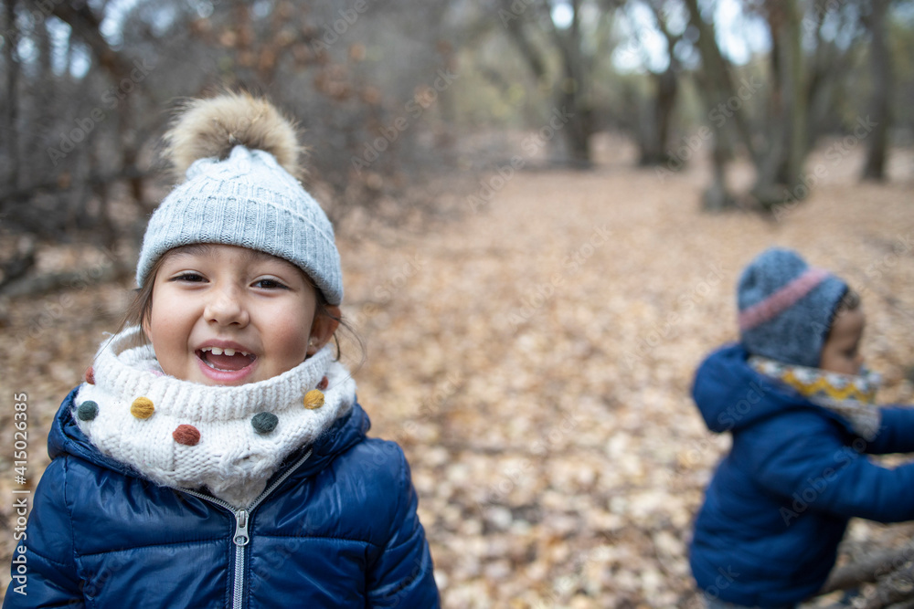 Cute girl with brother enjoying in forest during autumn Cute girl with brother enjoying in forest during autumn