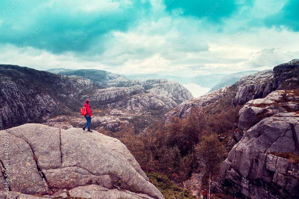 girl standing on a boulder and looks on the Norwegian fjord girl standing on a boulder and looks on the Norwegian fjord