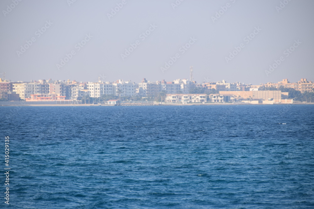 Hurghada disappears in the haze of the Red Sea, going by boat to the coral reef, view back, city skyline Hurgharda, Egypt