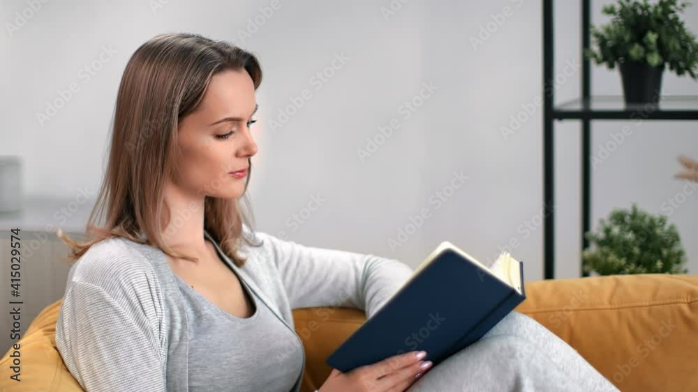 Lady read paper text book turning page relaxing alone. Medium close up shot on 4k RED camera Lady read paper text book turning page relaxing alone. Medium close up shot on 4k RED camera