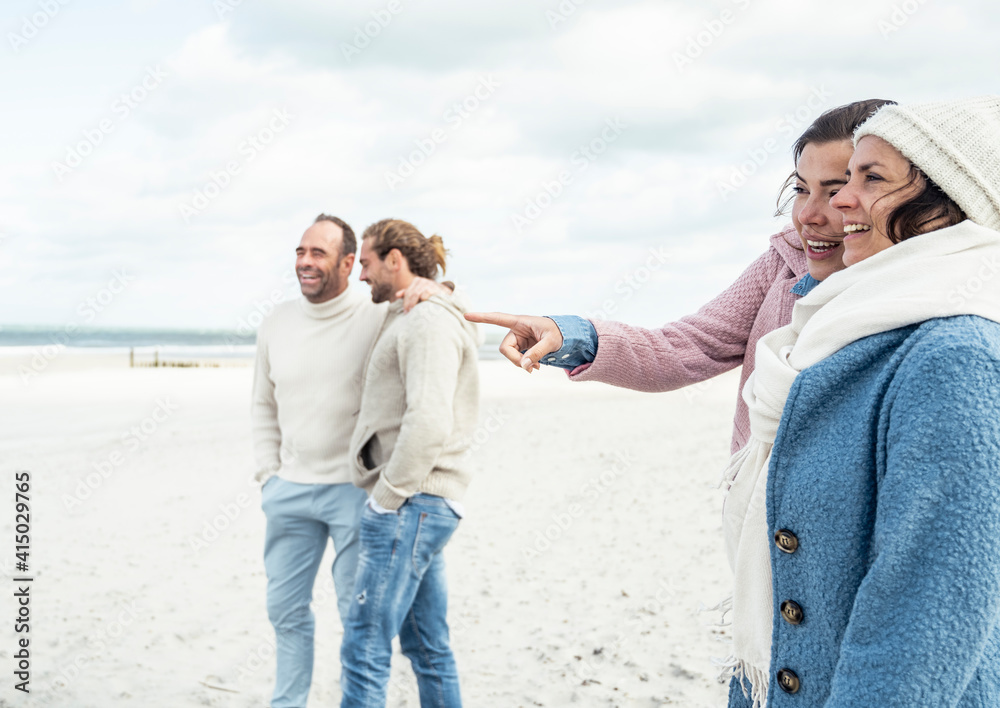 © Uwe Umst√§tter/Westend61 - Group of adult friends standing and talking on coastal beach © Uwe Umst√§tter/Westend61 - Group of adult friends standing and talking on coastal beach