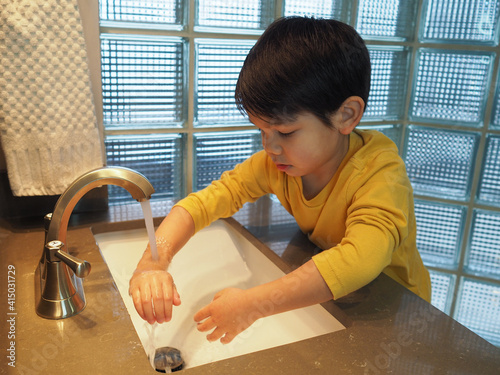 A boy washes his hands