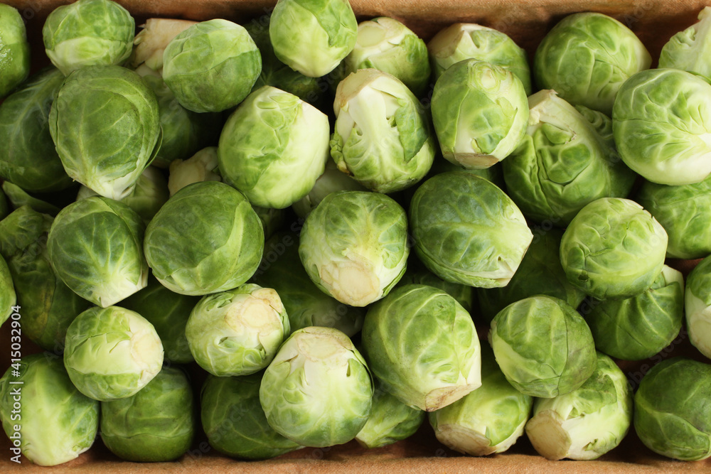 The heads of Brussels sprouts are randomly placed in a cardboard box. Closeup. View from above The heads of Brussels sprouts are randomly placed in a cardboard box. Closeup. View from above