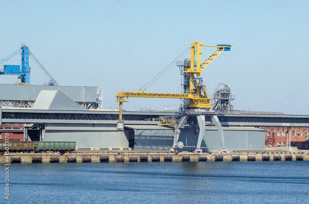 Lifting harbor cranes and railway wagons in the cargo seaport