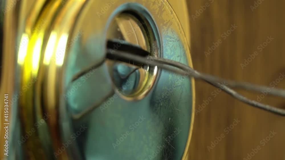 Gloved hands open the lock with a master key. A man opens the lock to ...