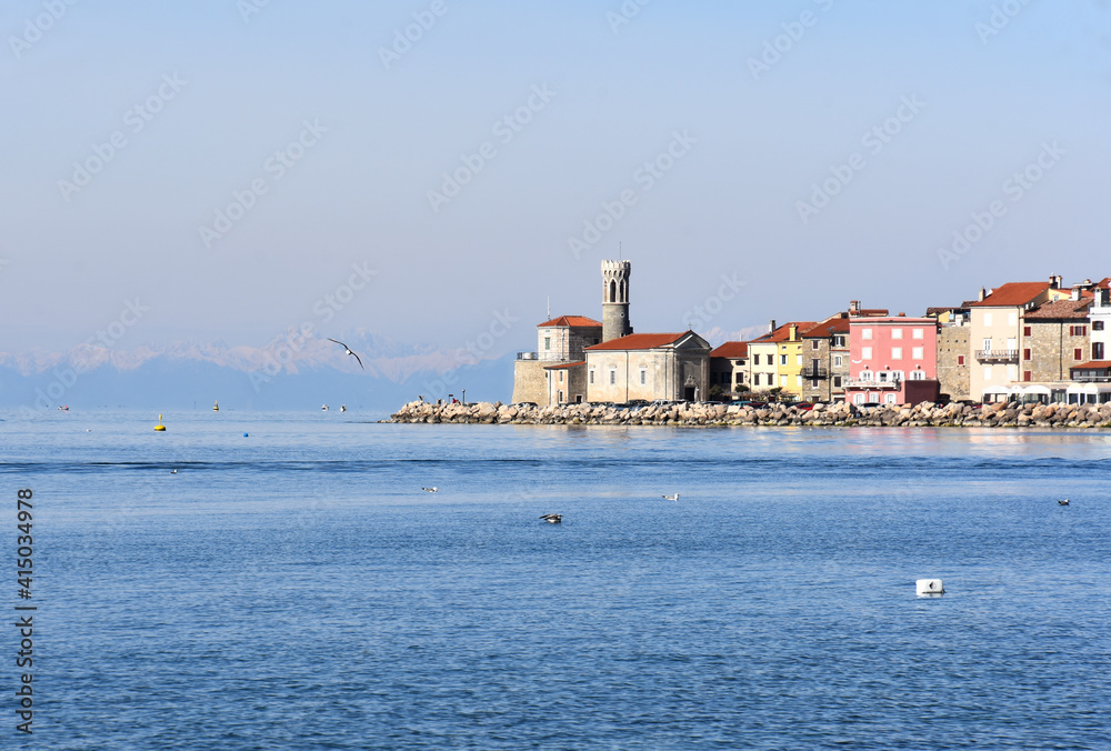Lighthouse at cape of medieval town Piran, Adriatic sea, Slovenia, seascape with gulls in front