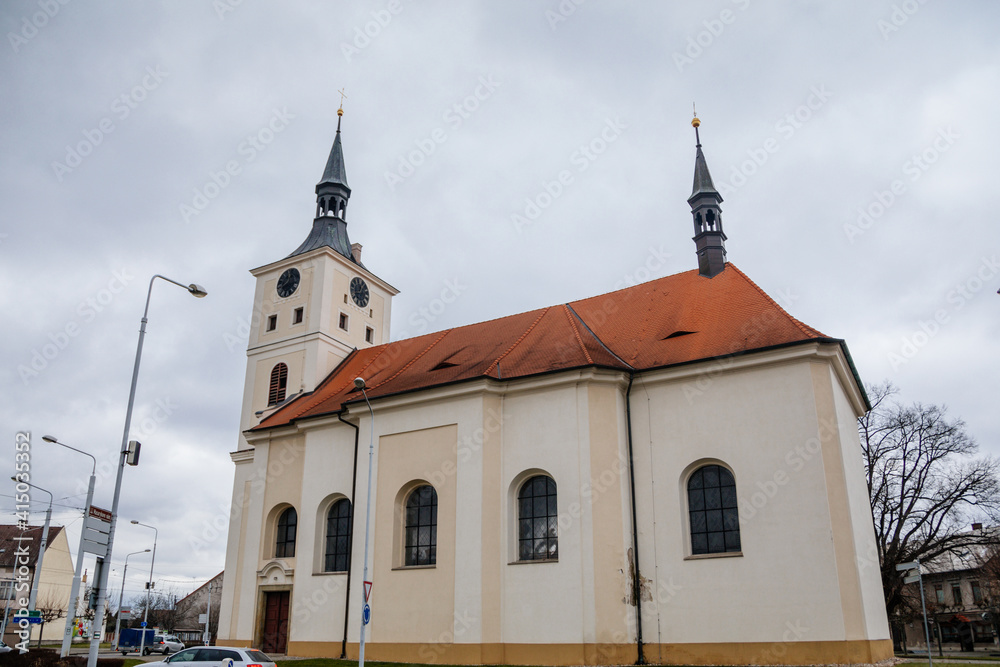 Baroque church of St. Mary Magdalene with clock tower at main Masaryk Square in city centre, spa resort in winter day, Lazne Bohdanec, Pardubice region, Czech Republic
