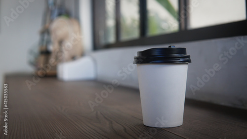 a paper cup of coffee in a cafe indoor 