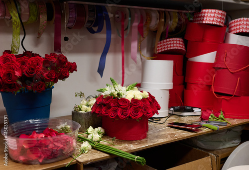 Flower box with red roses and white flowers on the table, flower box assembly process