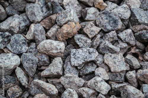 Close up picture of gravel stones on the ground. Top close up view photo with copy space. Pebble stones background. Natural large sea cobblestones wallpaper with different size and color gray texture.