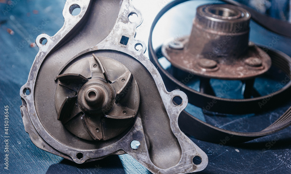 Fototapeta premium Used auto parts, coolant pump and wheel hub. Car repair concept.