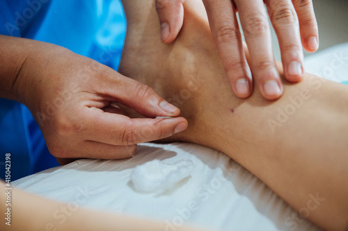 Mãos inserindo agulha em tratamento terapeutico photo