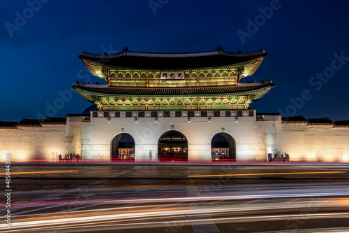 Amazing view of illuminated Gwanghwamun Gate in front of road with traffic light trails at night in Seoul