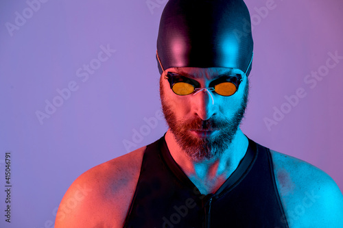 Portrait of a swimmer with cap and goggles looking down