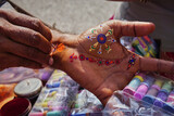 A street artist offering colorful hena painting onf hands, Jaipur, India