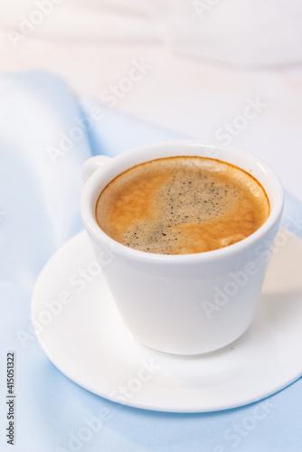 white cup of coffee on blue cloth