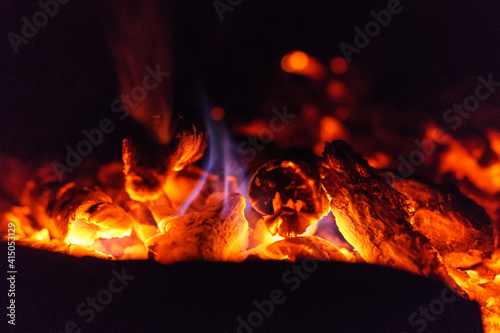 Close up of campfire burning wood hot red with blue little flame